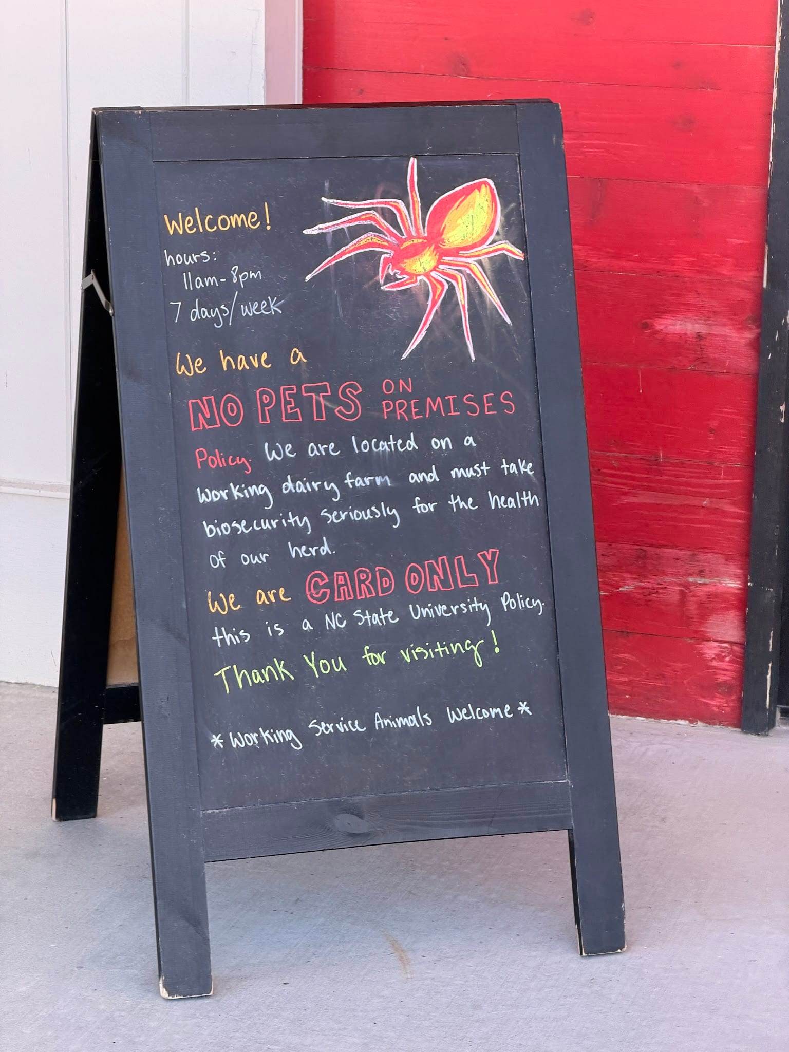 Visitor notice outside Howling Cow explaining cashless payment and the no-pets policy