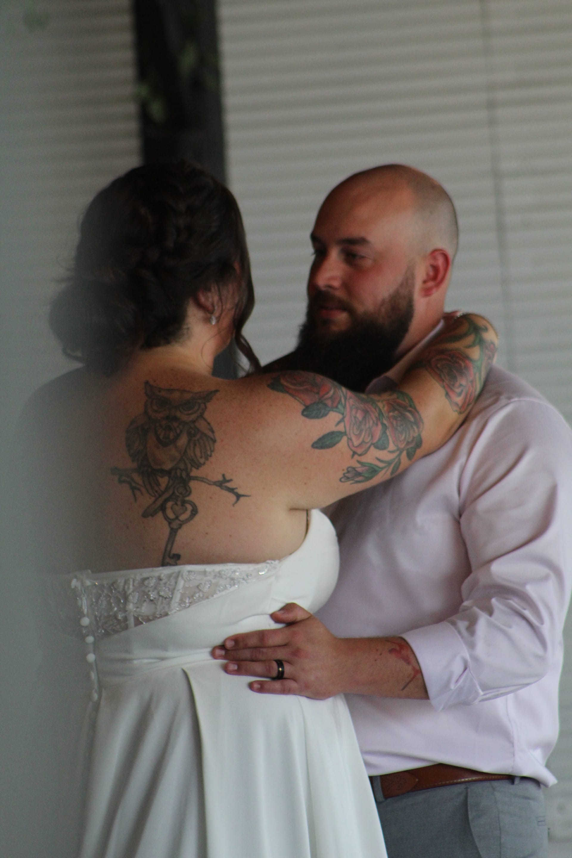 Tattooed bride and bearded groom share a tender embrace during their wedding at Scarborough House historic estate venue.