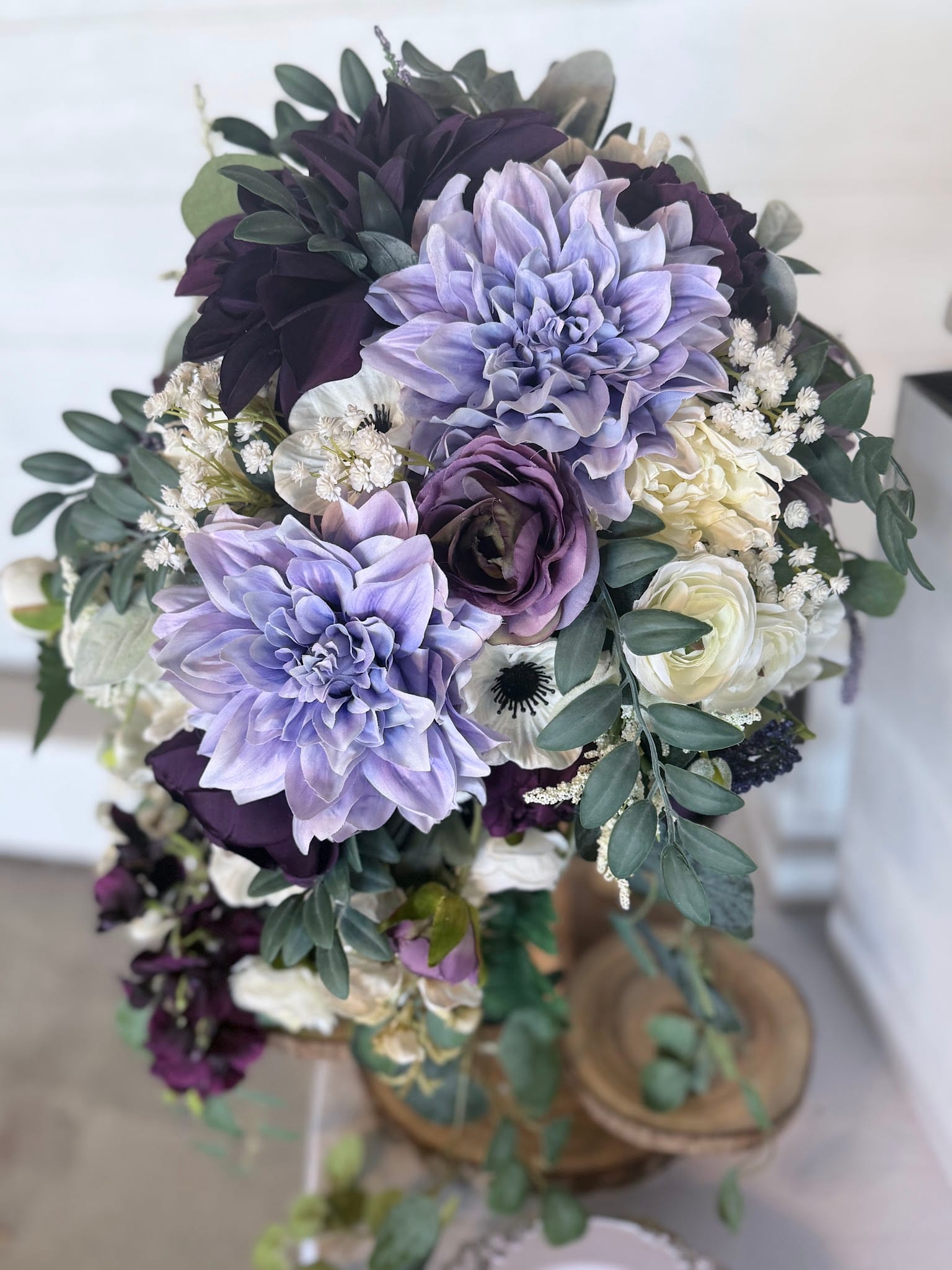 Lush bridal bouquet featuring lavender dahlias, deep plum roses, white anemones, ranunculus, baby's breath, and eucalyptus greenery arranged in a cascading style at Scarborough House.