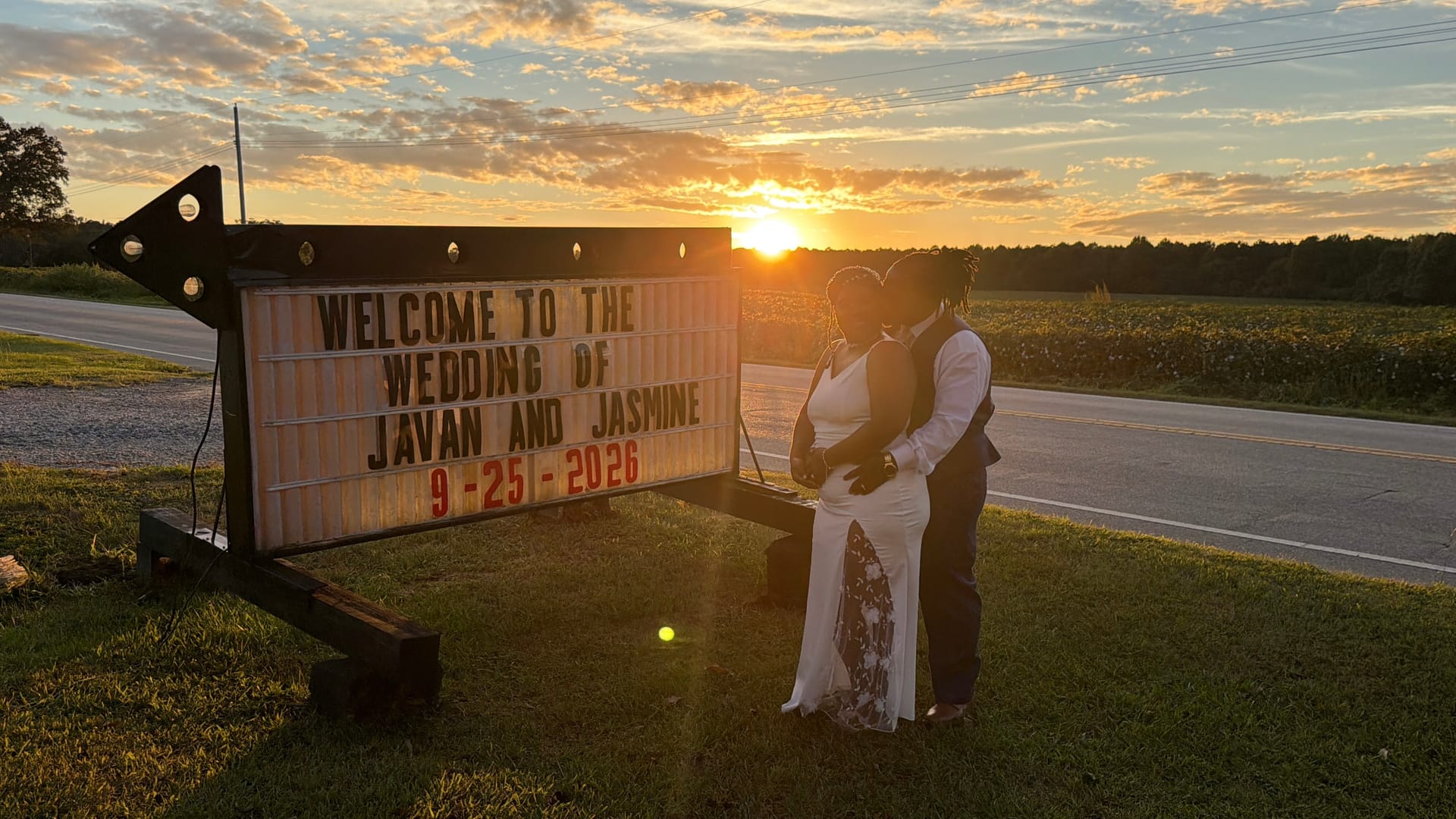 Bride and groom share a kiss at sunset beside a marquee sign welcoming guests to the wedding of Javan and Jasmine on September 25 2026 at Scarborough House.