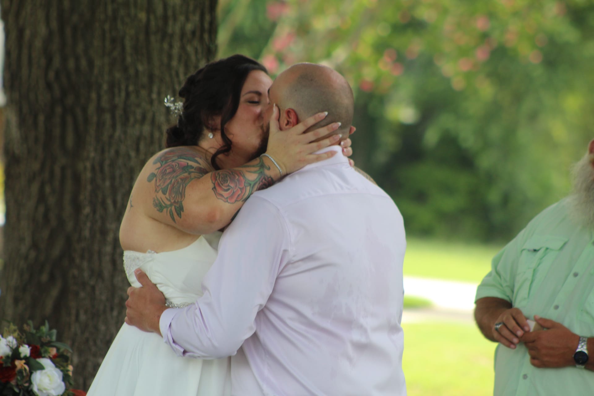Bride and groom share their first kiss as newlyweds during an outdoor wedding ceremony beneath the oak trees at Scarborough House historic estate.