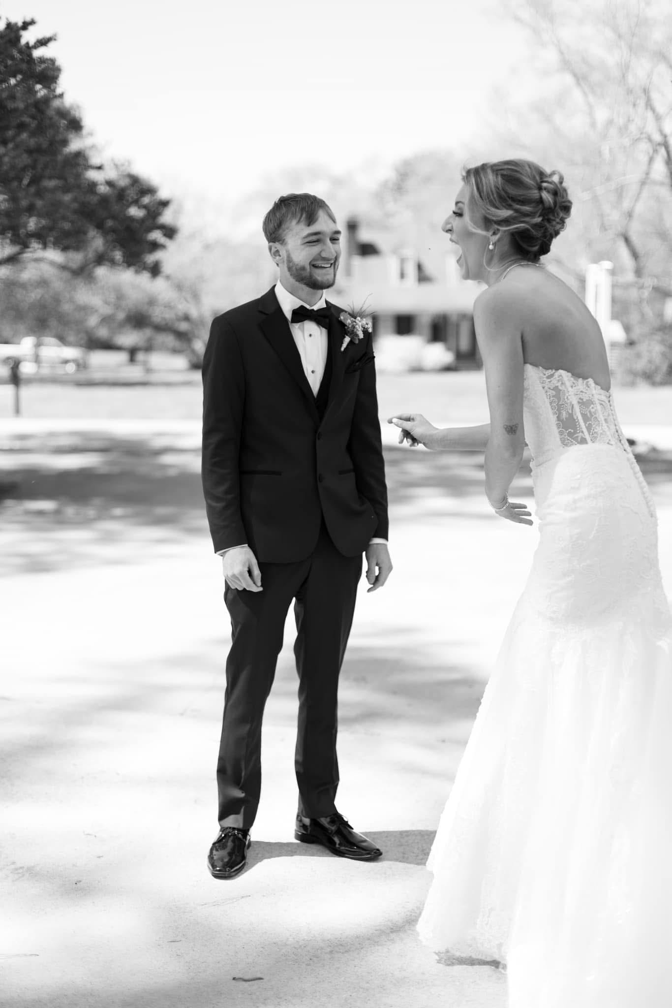 Bride and groom share a joyful laughing moment during their first look on the grounds of Scarborough House historic estate wedding venue.