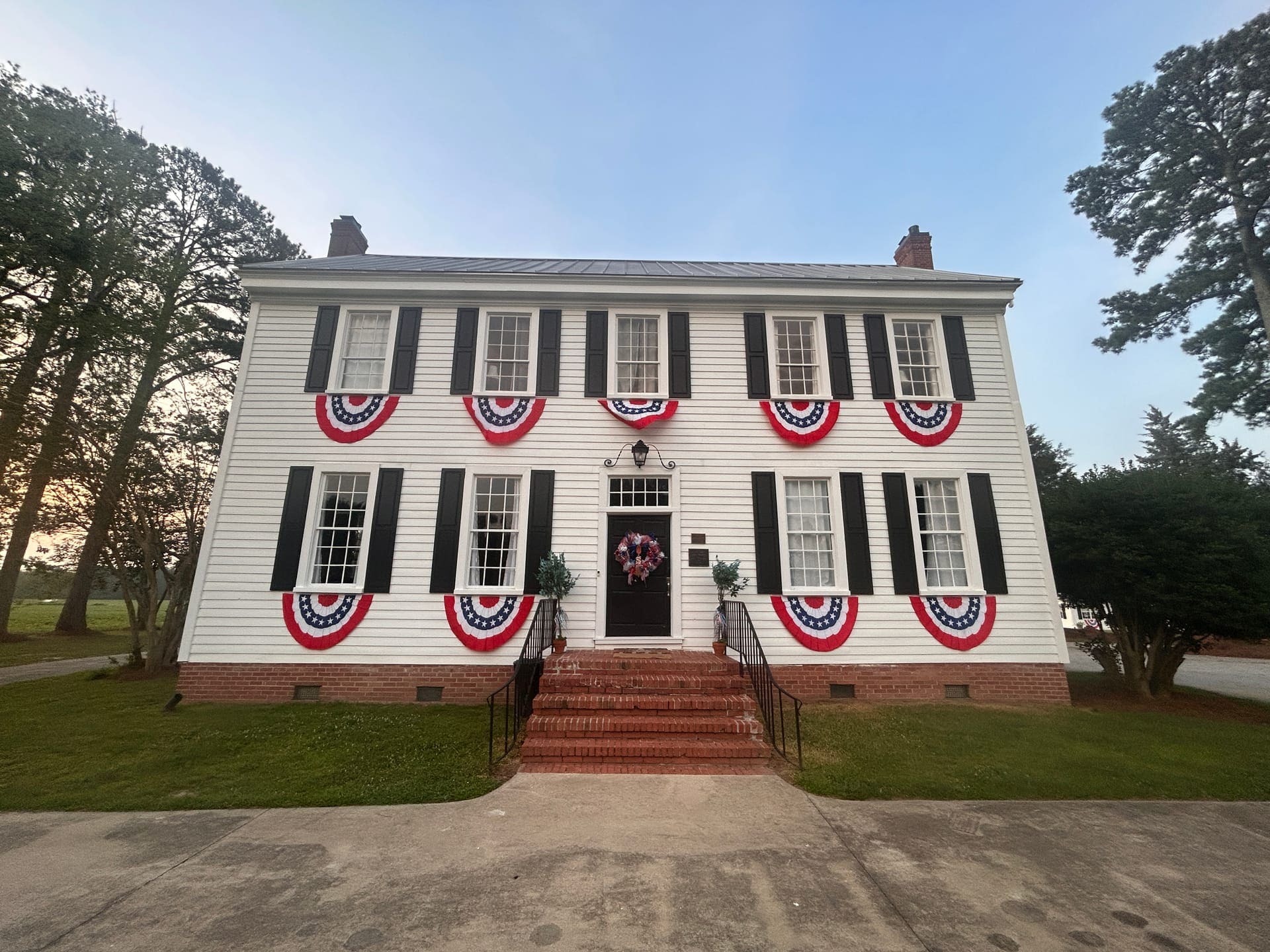 Scarborough House decorated with red, white, and blue bunting across its Federal-style facade