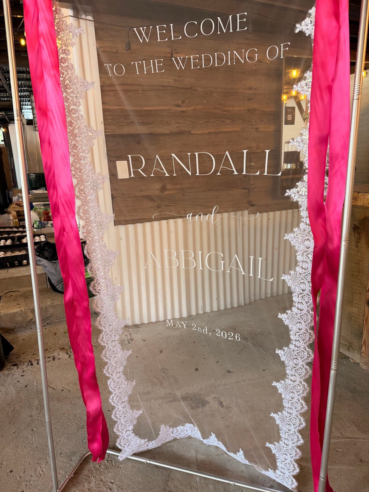 Acrylic wedding welcome sign with lace border and hot pink ribbon streamers at a Scarborough House wedding.