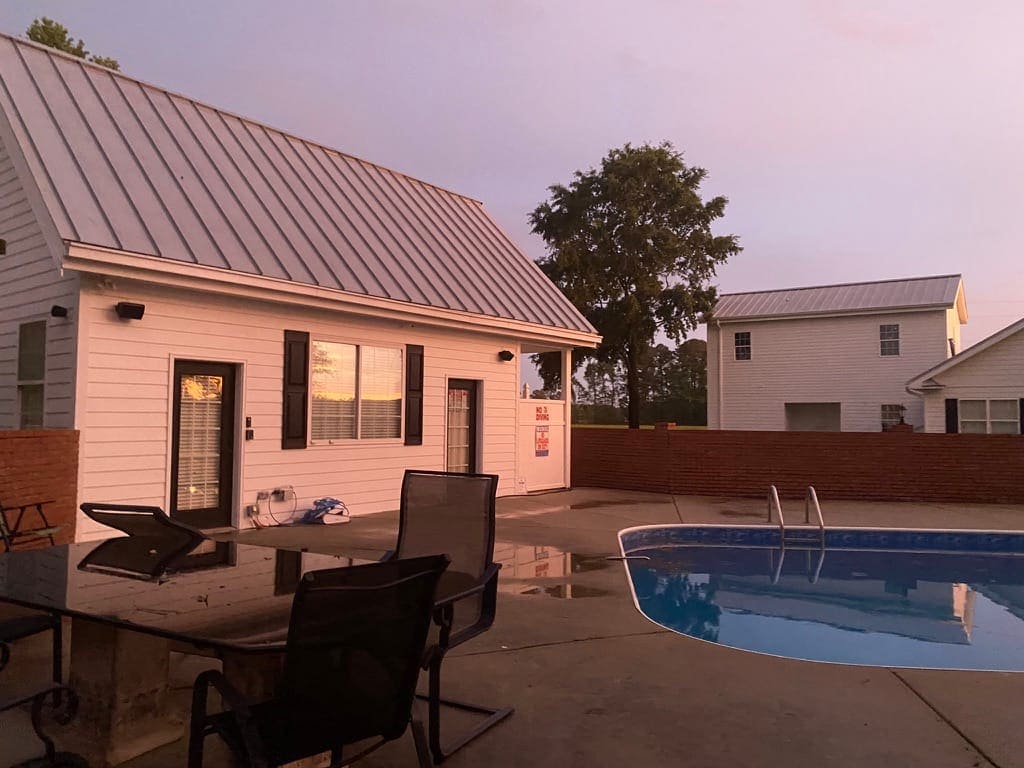 The Scarborough House Pool House and pool deck in soft early-morning light after rain.
