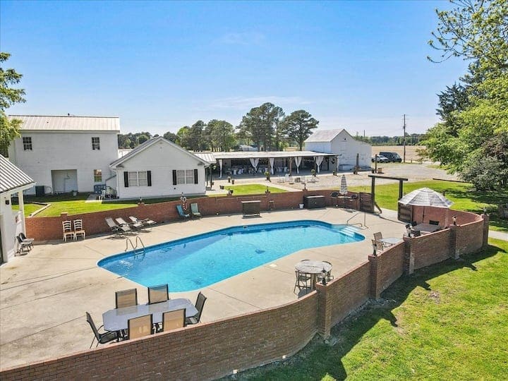 Aerial view of the Scarborough House pool, deck, Pool House, and nearby estate buildings.