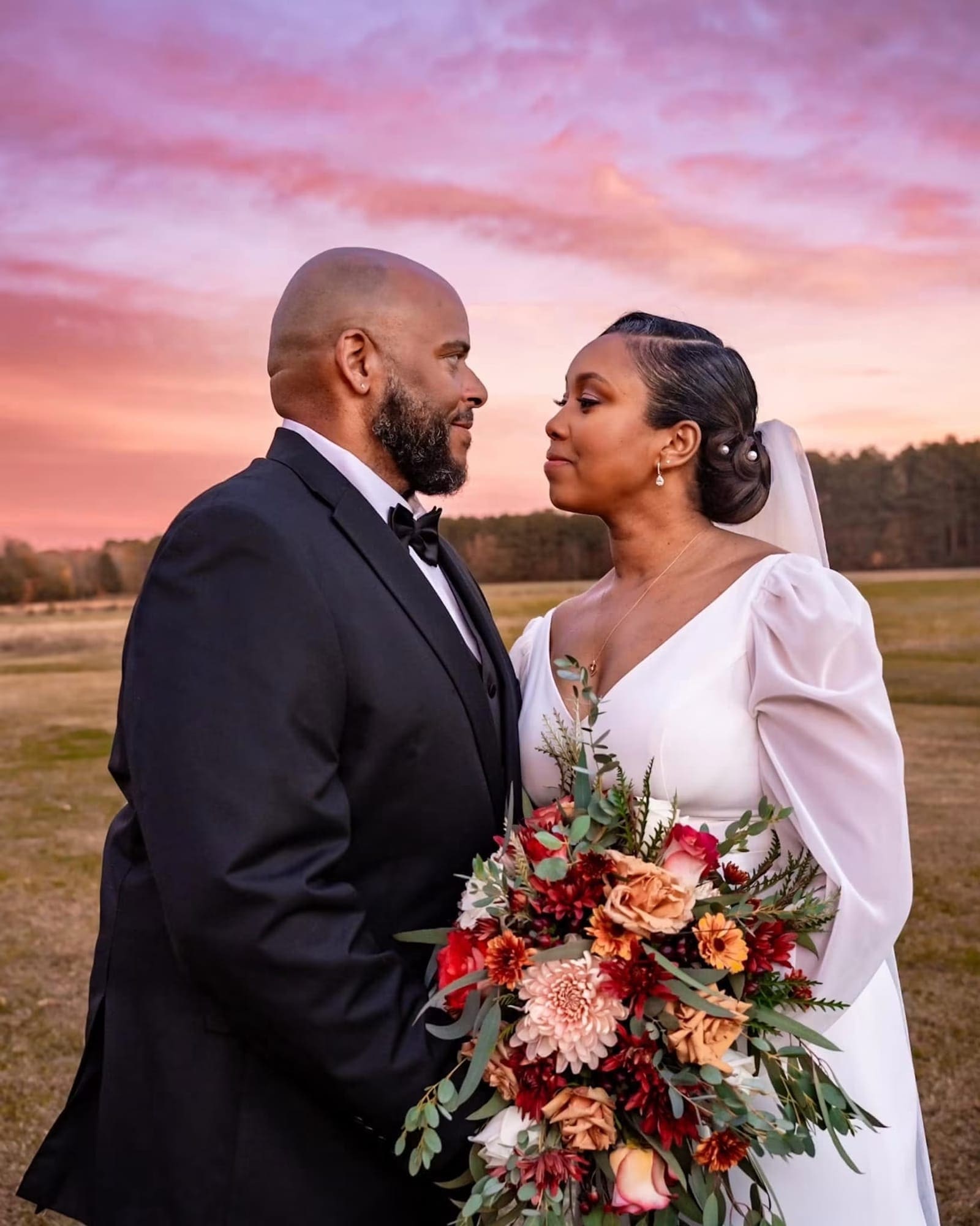 Bride and groom at golden hour under a pink October sunset in an open field at Scarborough House
