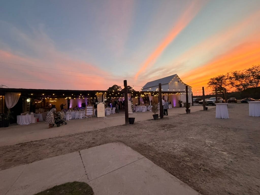 The Magnolia Pavilion at Scarborough House glowing at sunset under warm string lights