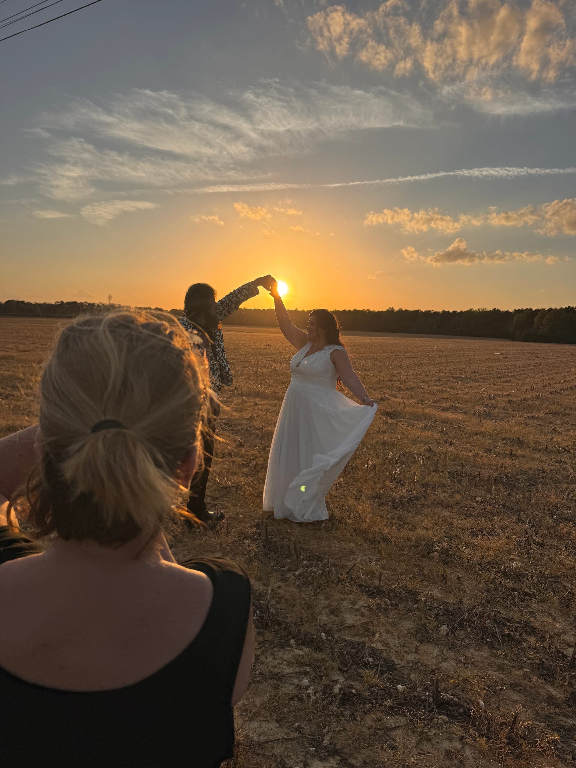 Bride in golden-hour light with veil in the field at Scarborough House