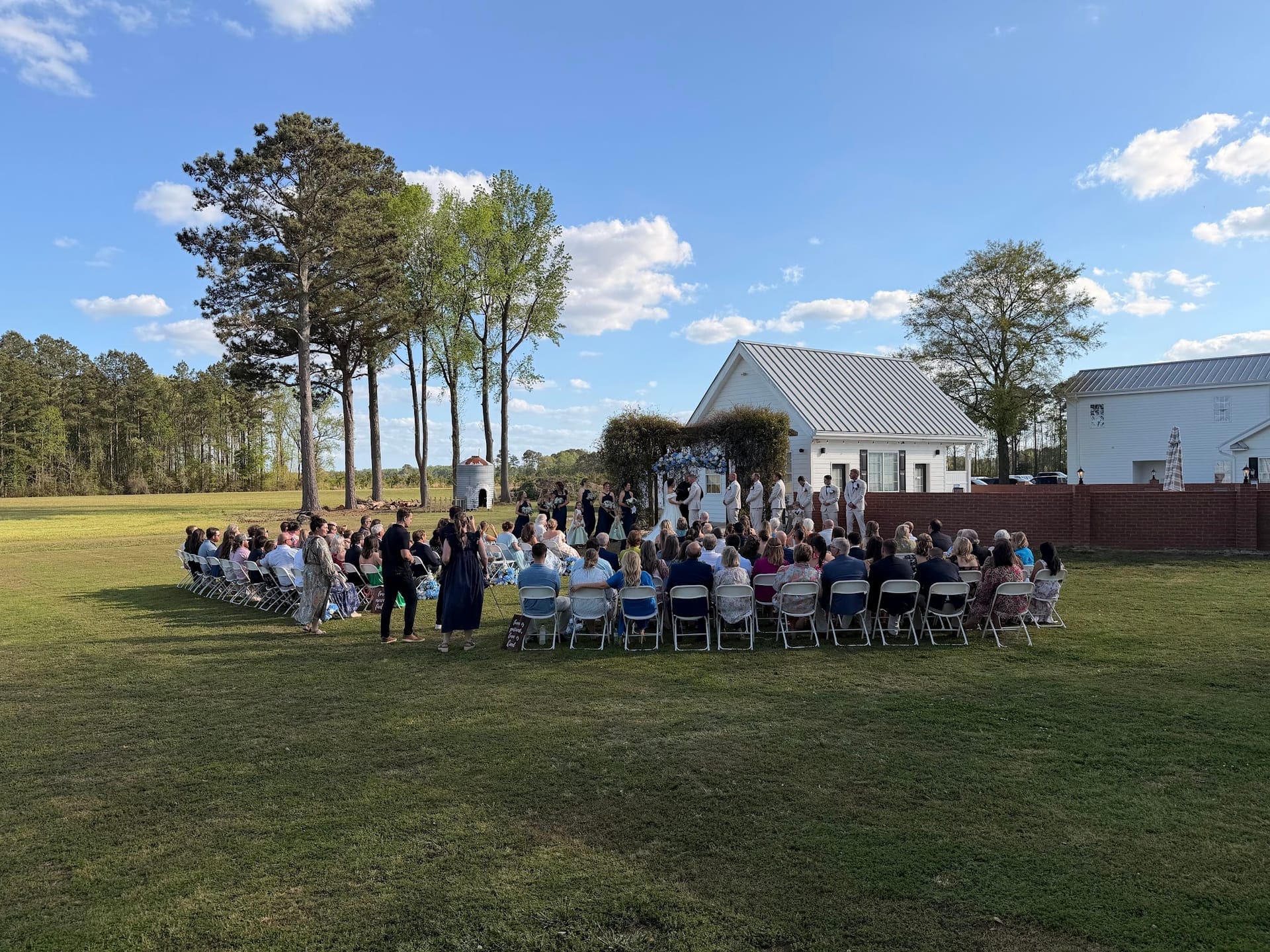 Lawn wedding ceremony with the white estate house at Scarborough House